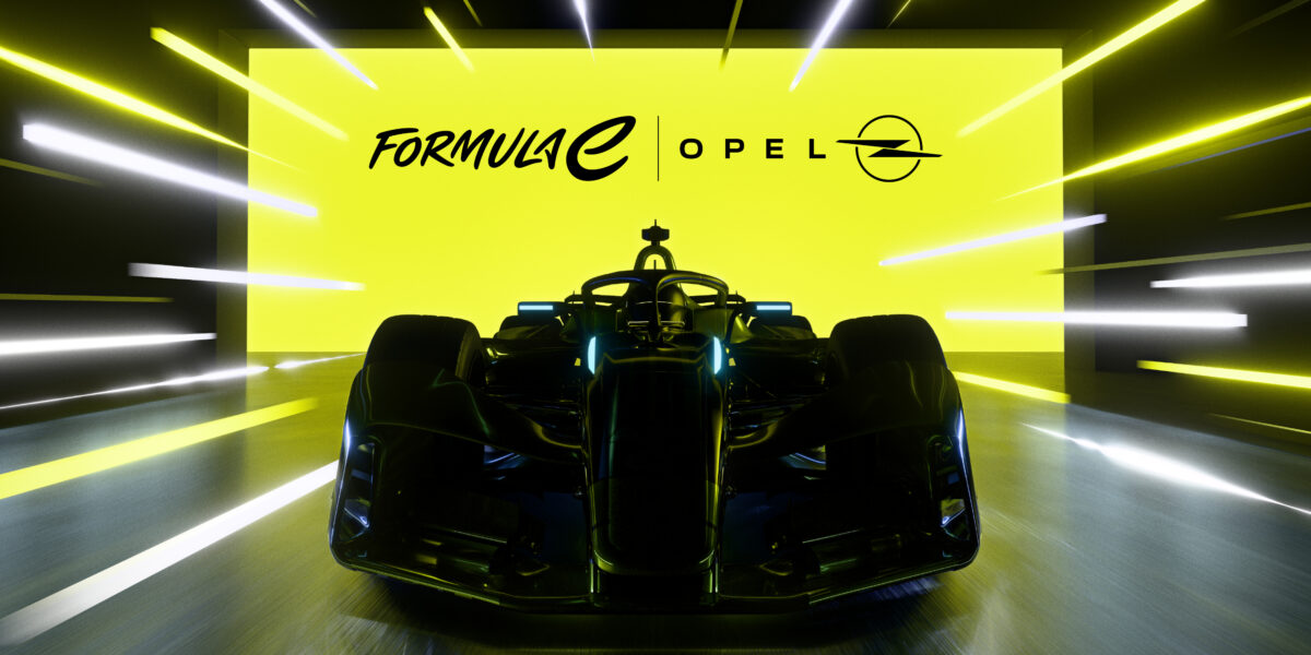 Frontansicht des Opel Formula E Gen4-Rennwagens in dunkler Lackierung, im Hintergrund eine leuchtend gelbe Wand mit den Logos von Formula E und Opel