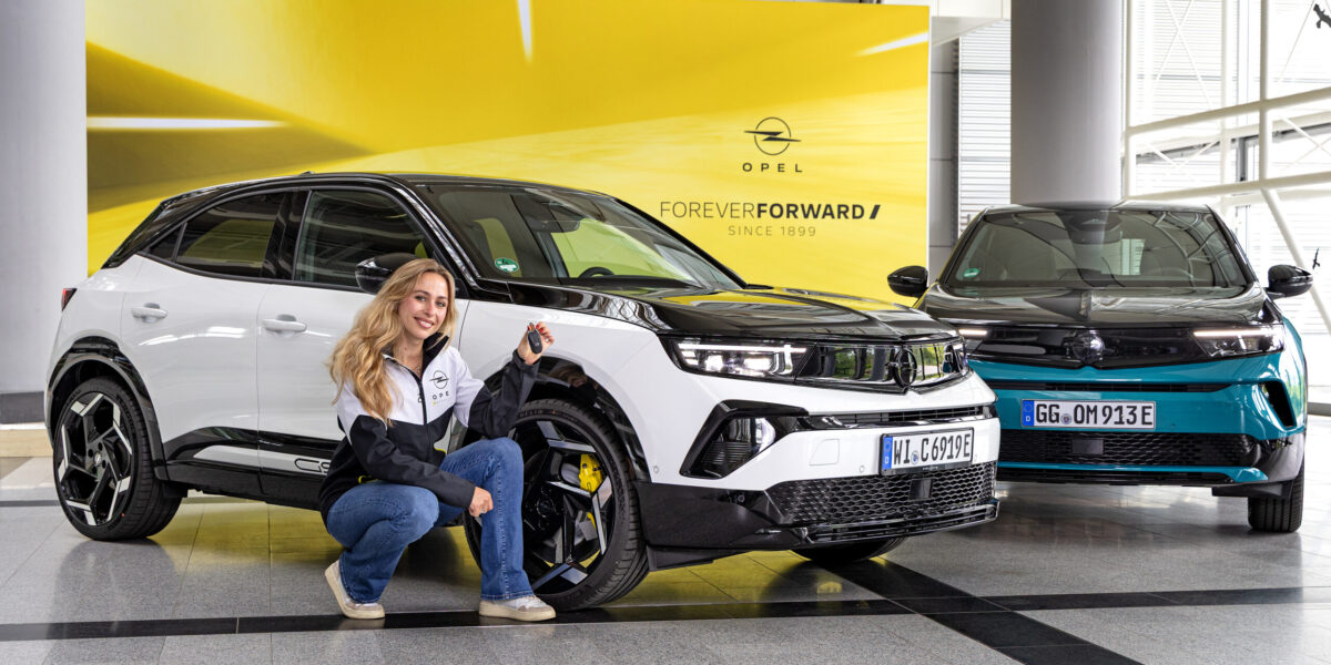 Rennfahrerin Sophia Lörsch vor ihrem neuen Dienstfahrzeug, dem Opel Mokka GSE,