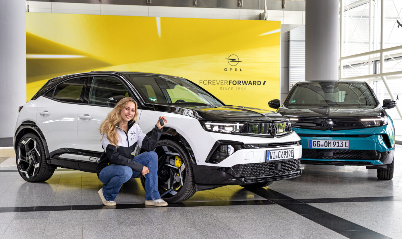 Rennfahrerin Sophia Lörsch vor ihrem neuen Dienstfahrzeug, dem Opel Mokka GSE,