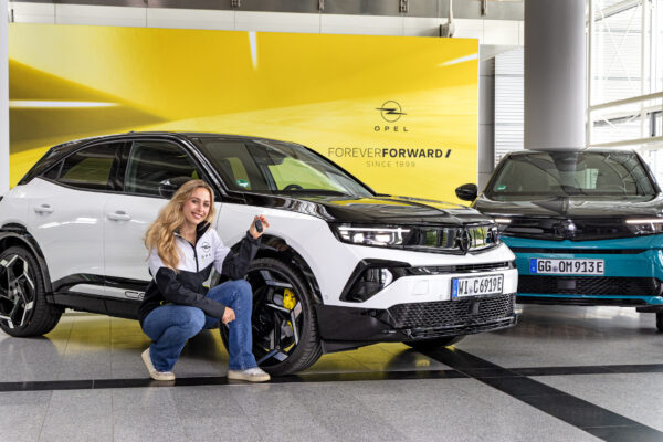 Rennfahrerin Sophia Lörsch vor ihrem neuen Dienstfahrzeug, dem Opel Mokka GSE,