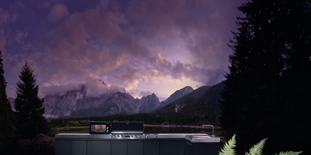 Miele Outdoor-Küche „Dreams" auf einer Bergwiese bei Nacht mit dramatisch violettem Gewitterhimmel