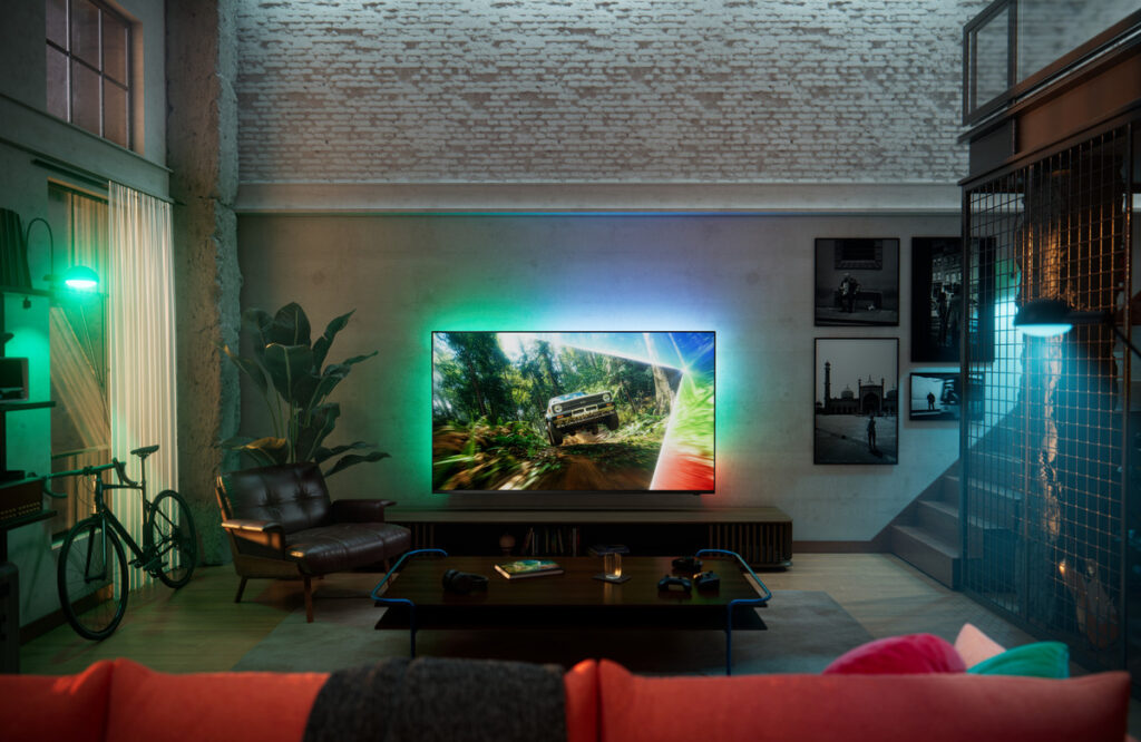 Philips Ambilight TV im Wohnzimmer mit leuchtendem RGB-Ambilight und Offroad-Spielszene auf dem Display