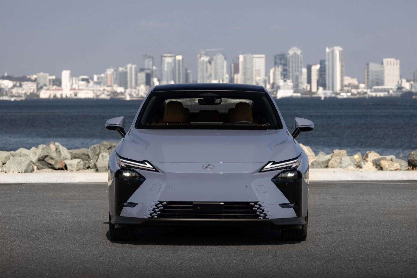Lexus ES 8. Generation in Grau, Frontansicht vor Stadtkulisse mit Gewässer