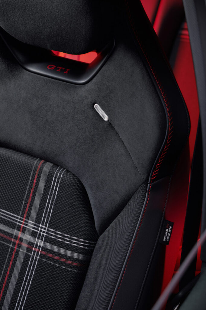 Sitz des VW ID. Polo GTI mit Karo-Stoff, GTI-Schriftzug auf der Kopfstütze und roten Ziernähten