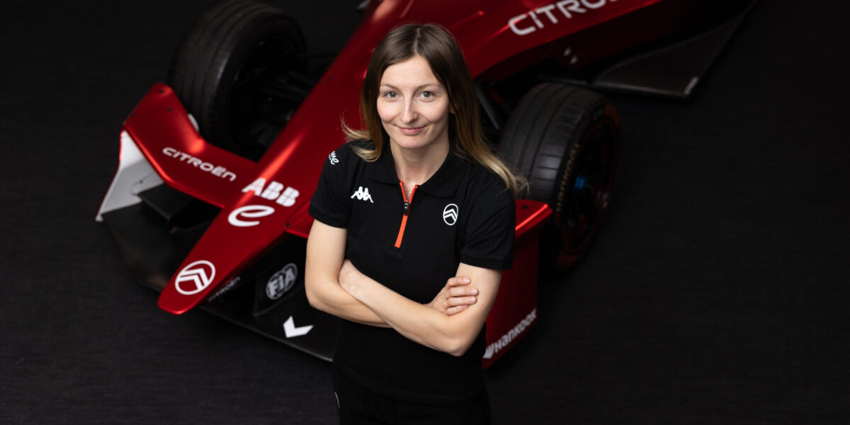 Doriane Pin in Citroën-Teamkleidung vor rotem Formel-E-GEN4-Fahrzeug im Studio