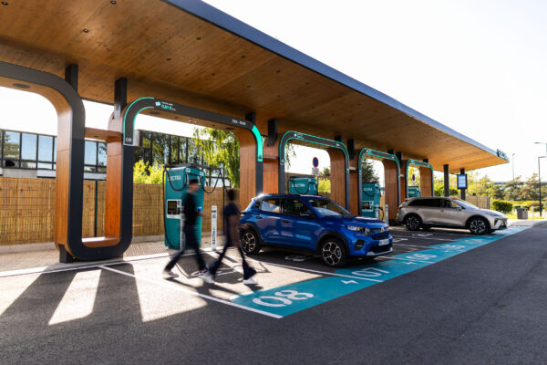 Electra-Schnellladestation mit blauen SUVs an türkisfarbenen Ladepunkten unter Holzdach