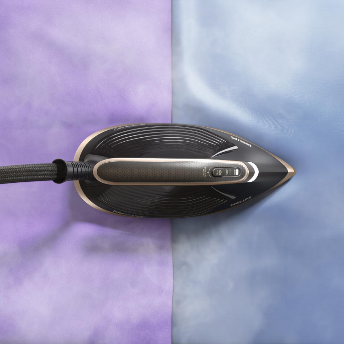 Philips PerfectCare 8000 Bügeleisen von oben auf lila und blauem Stoff mit sichtbarem Dampf