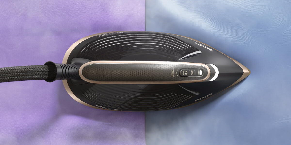 Philips PerfectCare 8000 Bügeleisen von oben auf lila und blauem Stoff mit sichtbarem Dampf