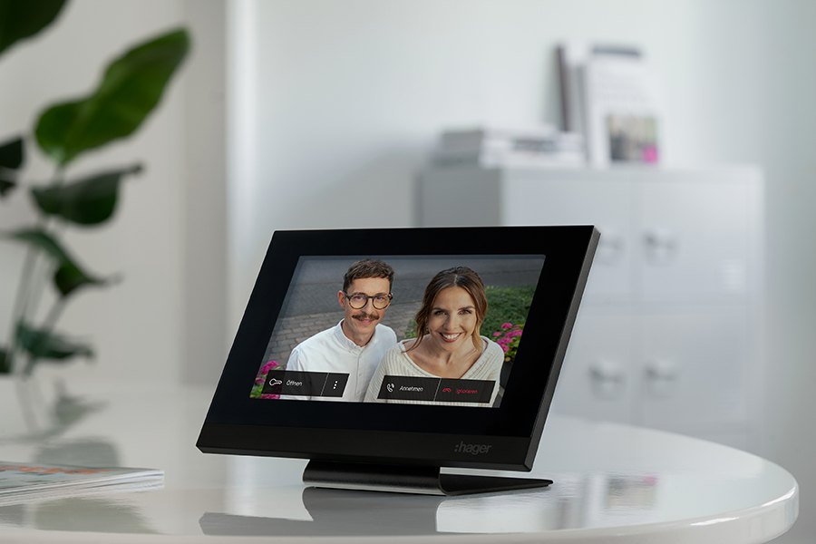 Hager intercom view als Tischaufsteller mit aktivem Videoanruf zweier Besucher auf weißem Bürotisch