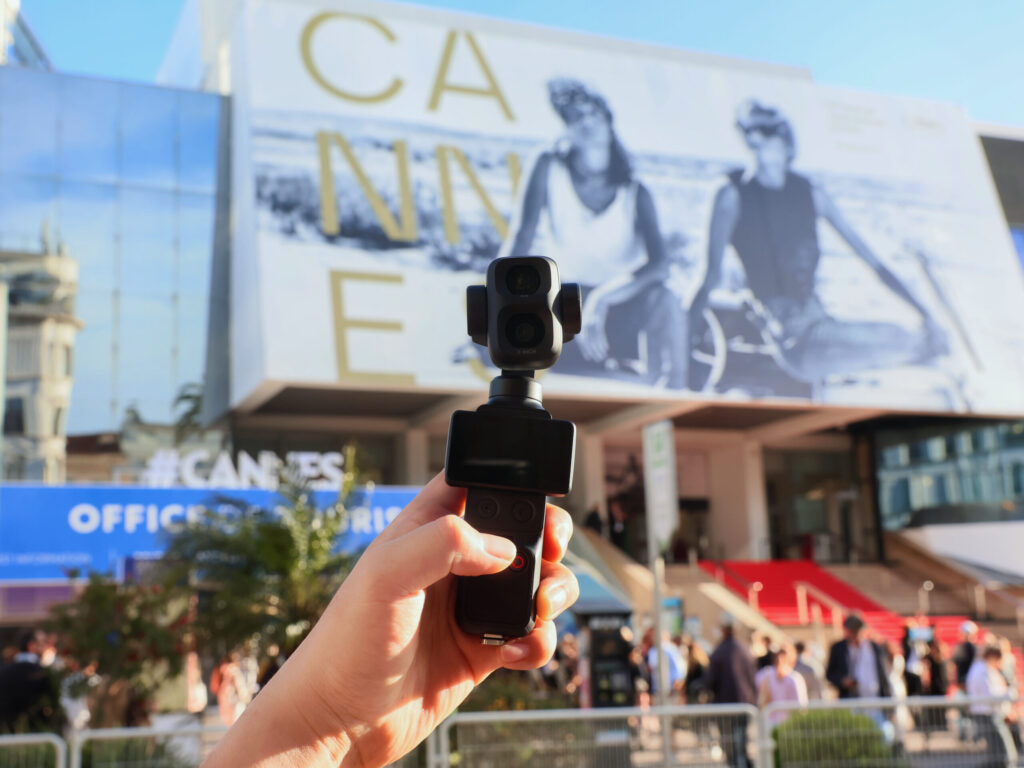 DJI Osmo Pocket 4P mit Dual-Objektiv, gehalten vor dem Palais des Festivals in Cannes