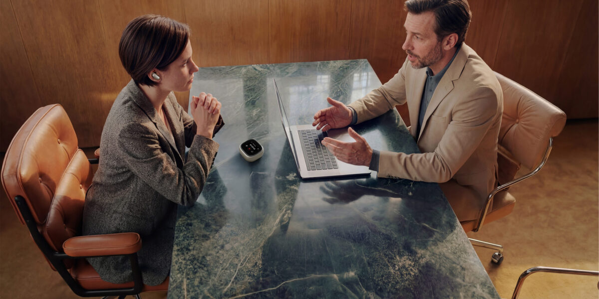 Frau mit soundcore Liberty 5 Pro Max im Ohr und Ladecase auf Marmortisch beim Business-Meeting