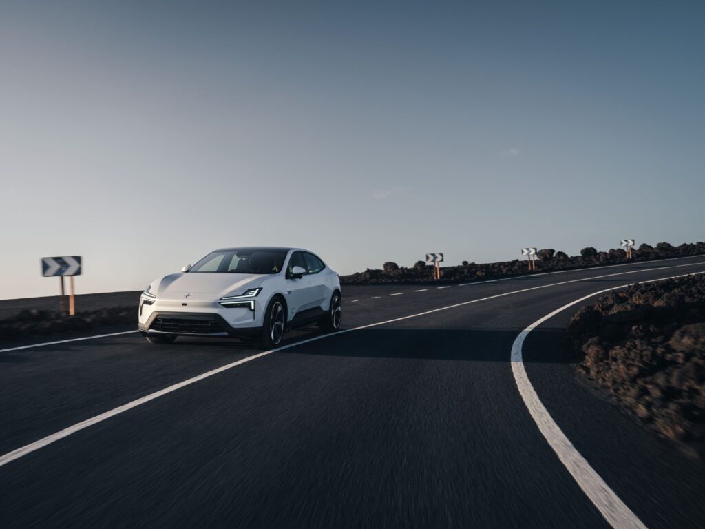 Polestar 4 Coupé 2026 in Weiß auf kurvenreicher Landstraße in Vulkanlandschaft