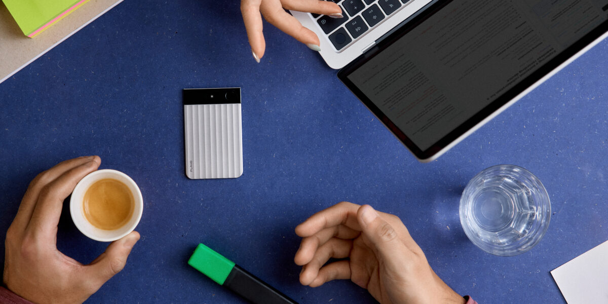 Plaud Note Diktiergerät auf blauem Schreibtisch neben MacBook, Espresso und Textmarker – Büro-Setting von oben
