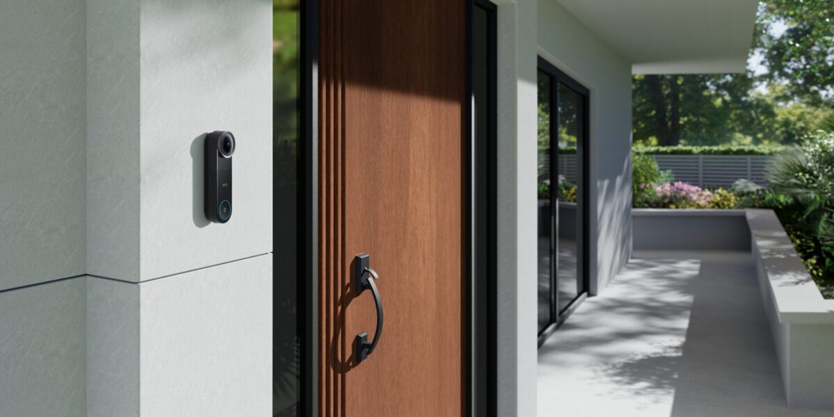 eufy Video Doorbell S4 an weißer Hauswand neben brauner Holzhaustür eines modernen Einfamilienhauses