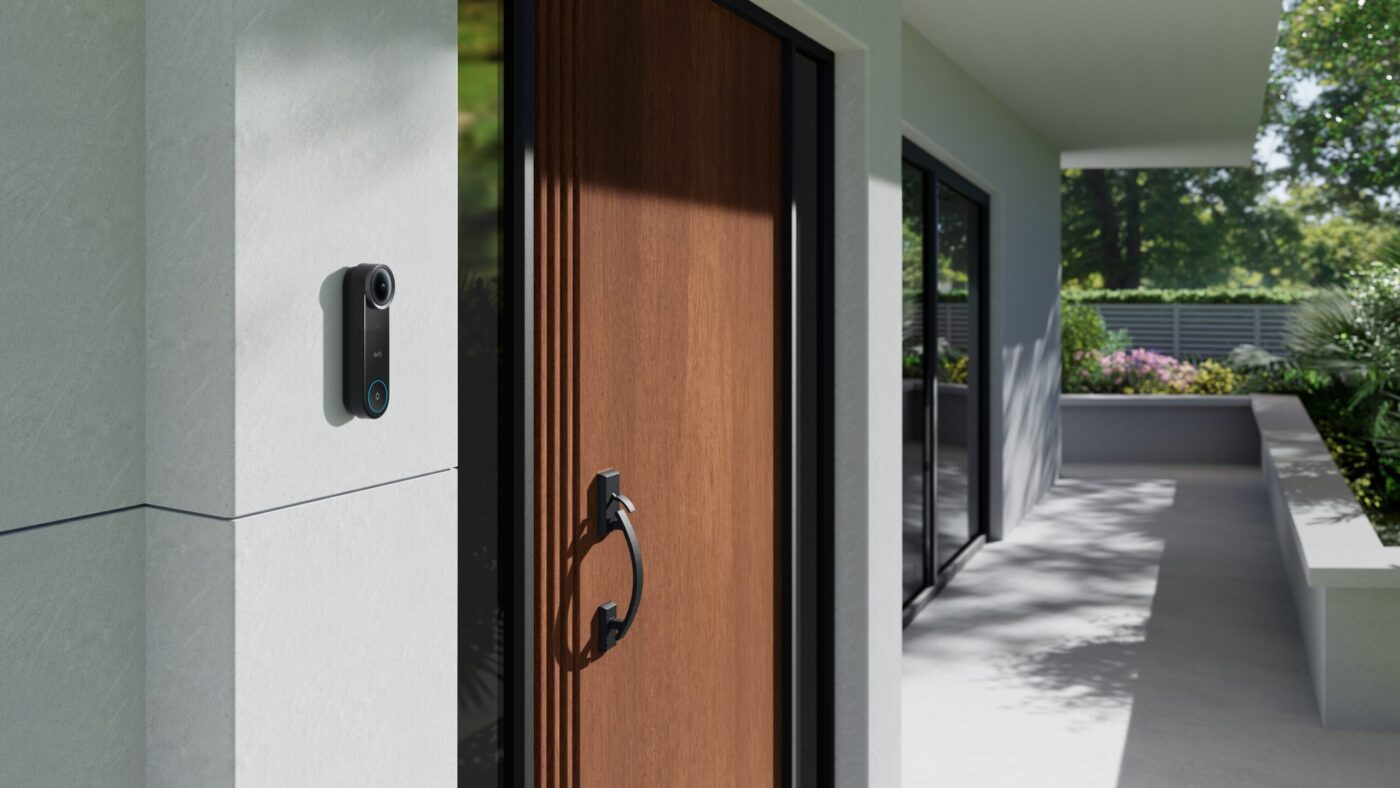 eufy Video Doorbell S4 an weißer Hauswand neben brauner Holzhaustür eines modernen Einfamilienhauses