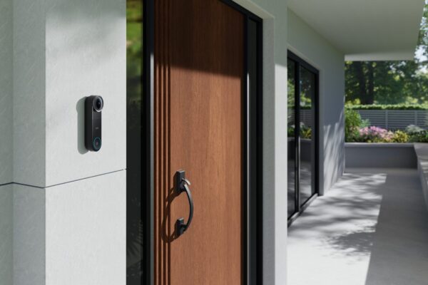 eufy Video Doorbell S4 an weißer Hauswand neben brauner Holzhaustür eines modernen Einfamilienhauses