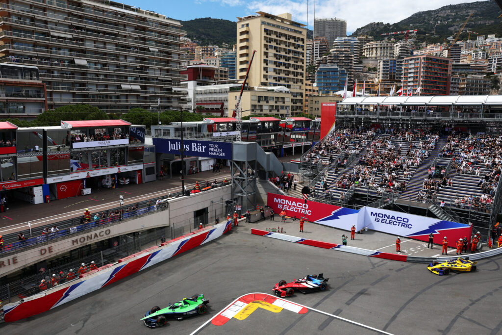 Drei Formel-E-Boliden in der engen Hafenschikane des Monaco E-Prix vor vollen Tribünen