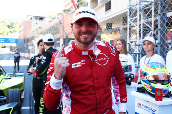 Oliver Rowland im roten Nissan-Rennoverall zeigt Daumen hoch nach Sieg beim Monaco E-Prix