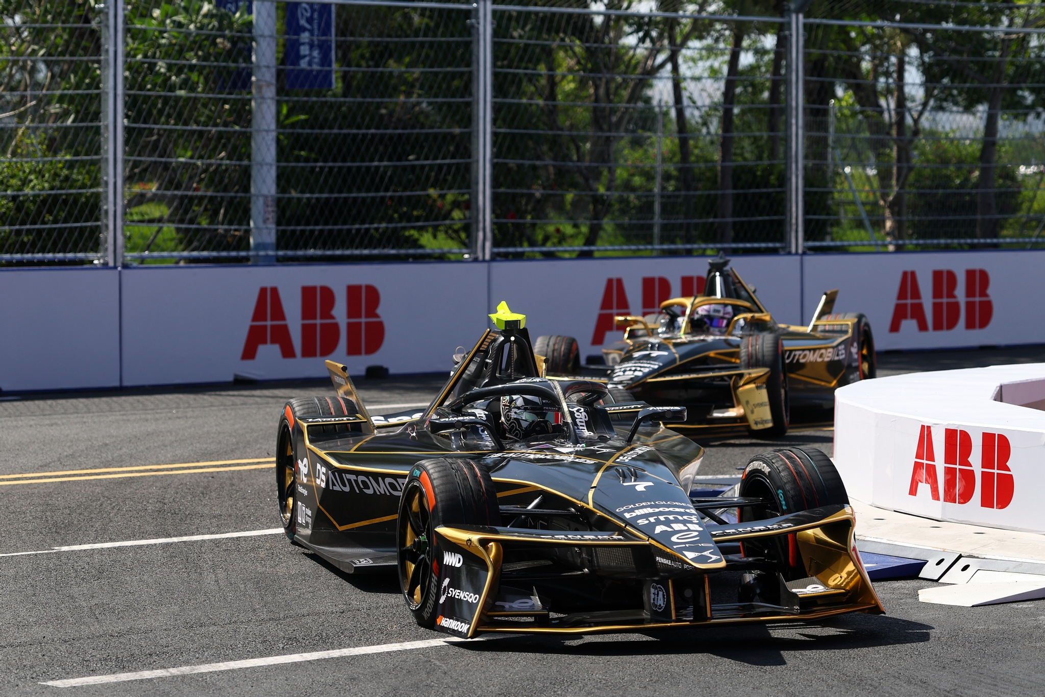 Zwei DS Automobiles Formula-E-Fahrzeuge in Schwarz-Gold beim E-Prix in Sanya vor ABB-Streckenbanden