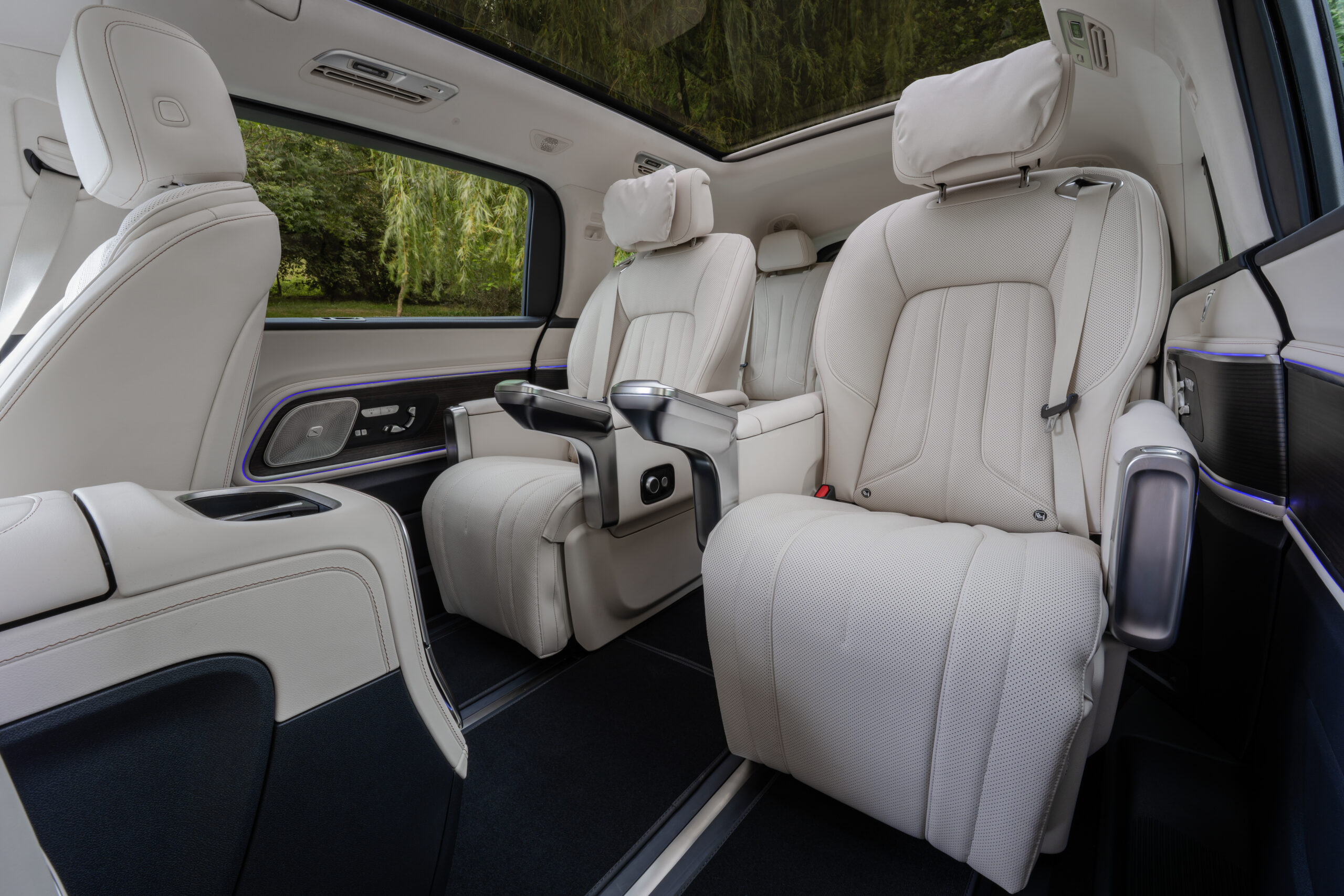 Mercedes VLE Innenraum mit cremefarbenen Leder-Einzelsitzen, blauer Ambientebeleuchtung und Panoramadach