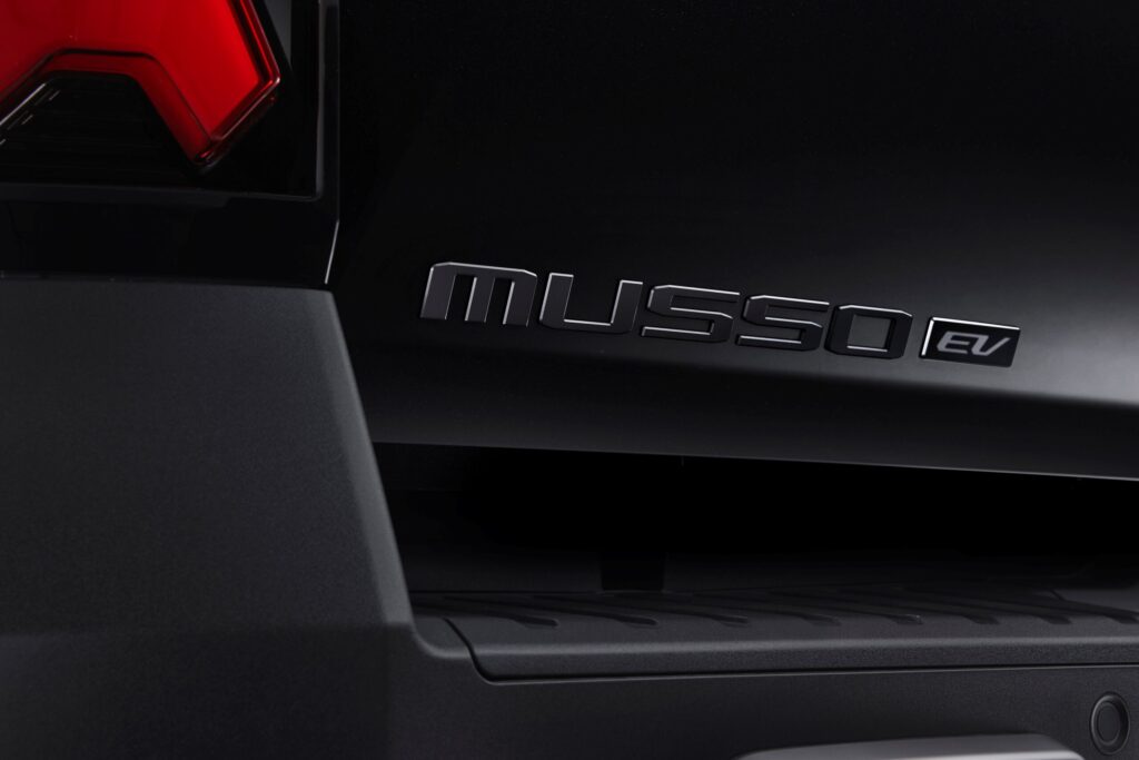 Schwarzes „MUSSO EV"-Emblem an der Karosserie des KGM Musso EV Black Edition