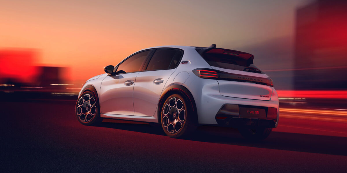 Peugeot E-208 GTi in Weiß von hinten auf nächtlicher Straße bei Sonnenuntergang