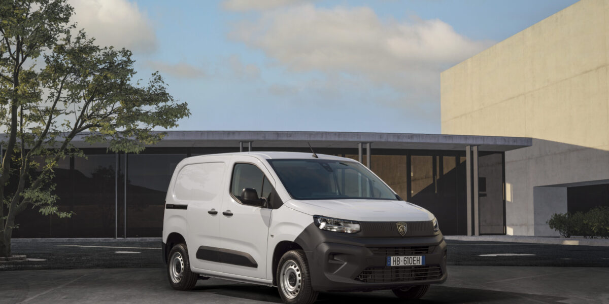 Peugeot Partner ACTIVE in Weiß, Frontansicht schräg links, parkend vor modernem Gebäude