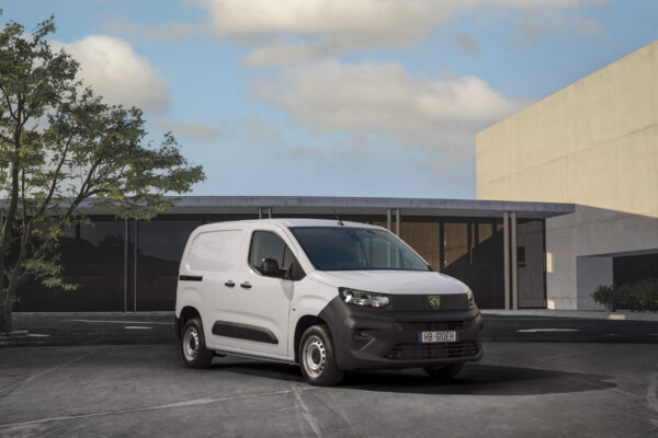Peugeot Partner ACTIVE in Weiß, Frontansicht schräg links, parkend vor modernem Gebäude