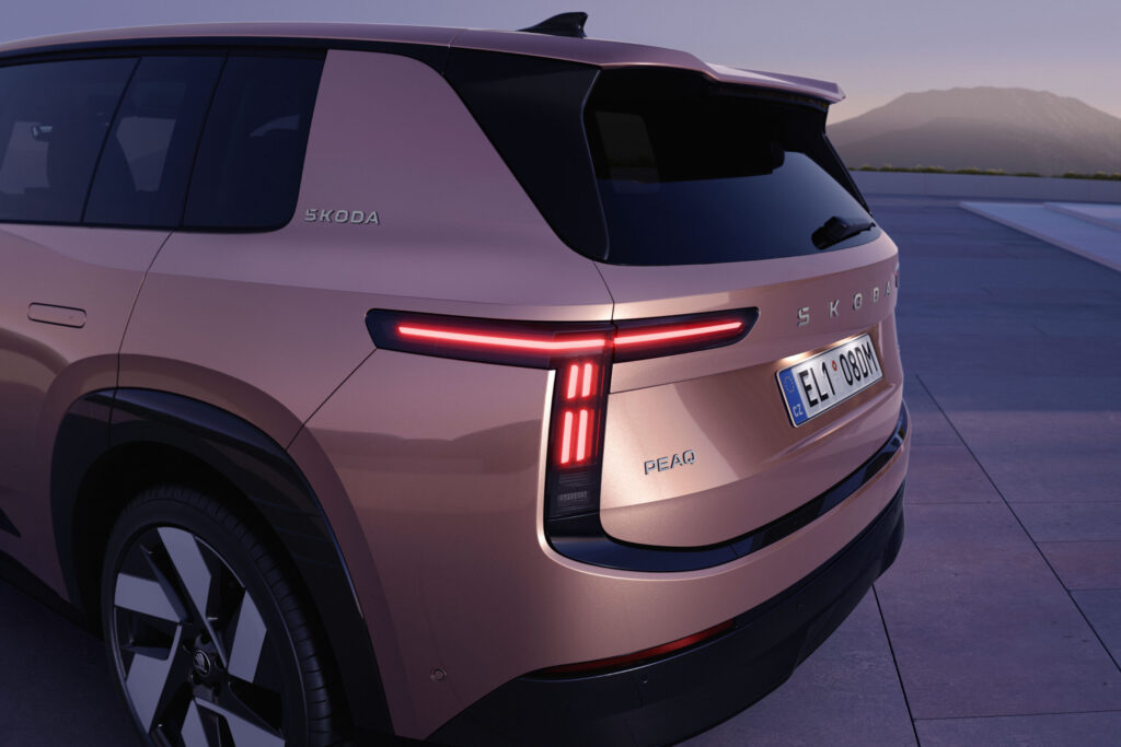 Škoda Peaq Heck in Kupfer-Rosé mit leuchtenden LED-Rückleuchten bei Abenddämmerung