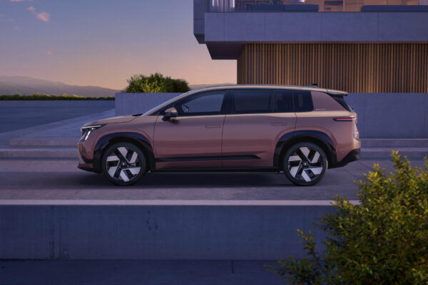 Škoda Peaq in Bronze-Metallic, Seitenansicht vor modernem Gebäude bei Abenddämmerung