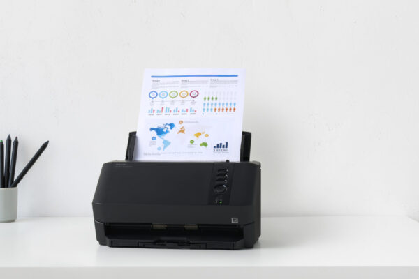 Ricoh SP-2240N Dokumentenscanner auf weißem Schreibtisch mit eingelegtem Infografik-Dokument im ADF