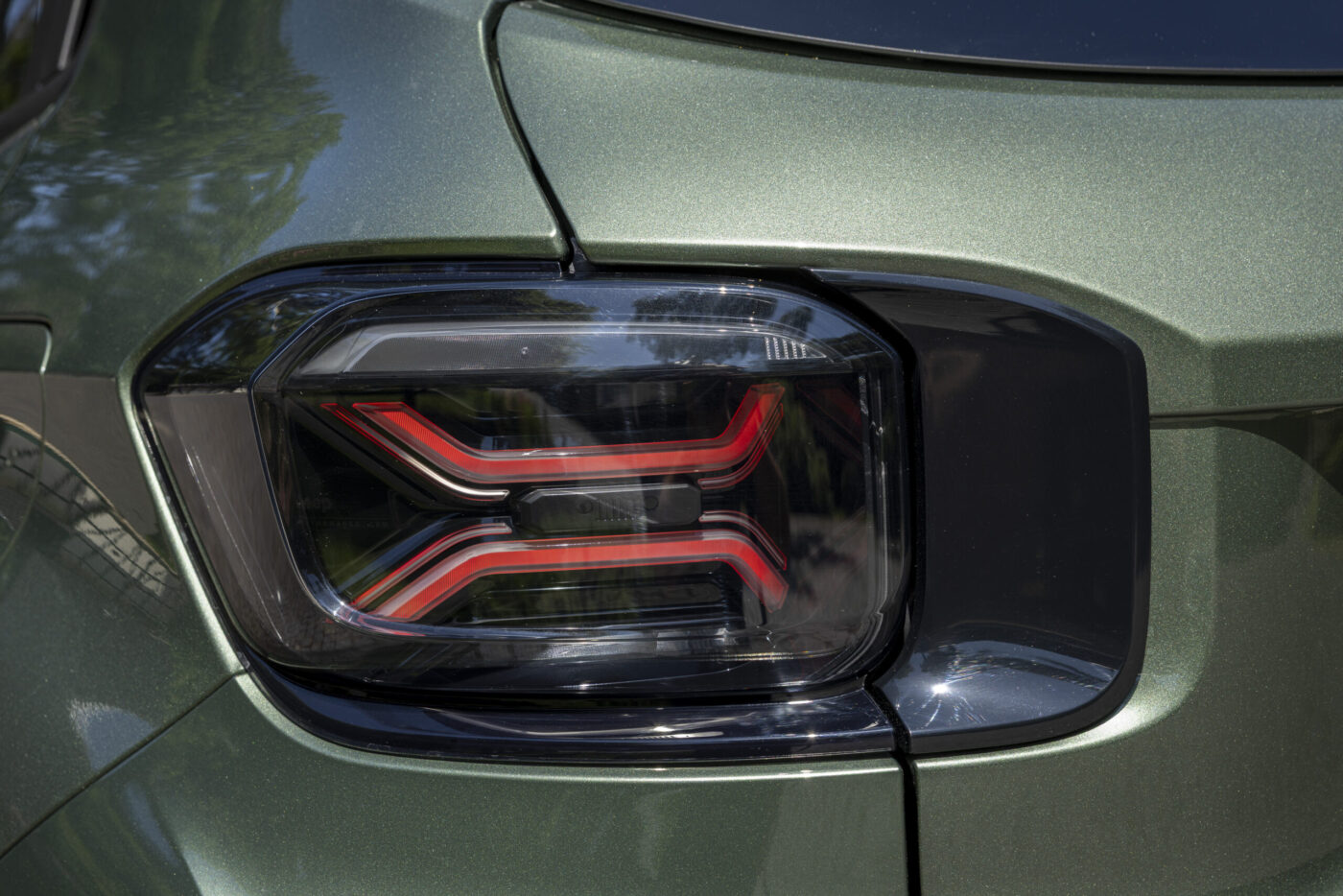 LED-Rücklicht des Jeep Avenger 2026 mit X-förmigem roten Lichtleiter an olivgrüner Karosserie
