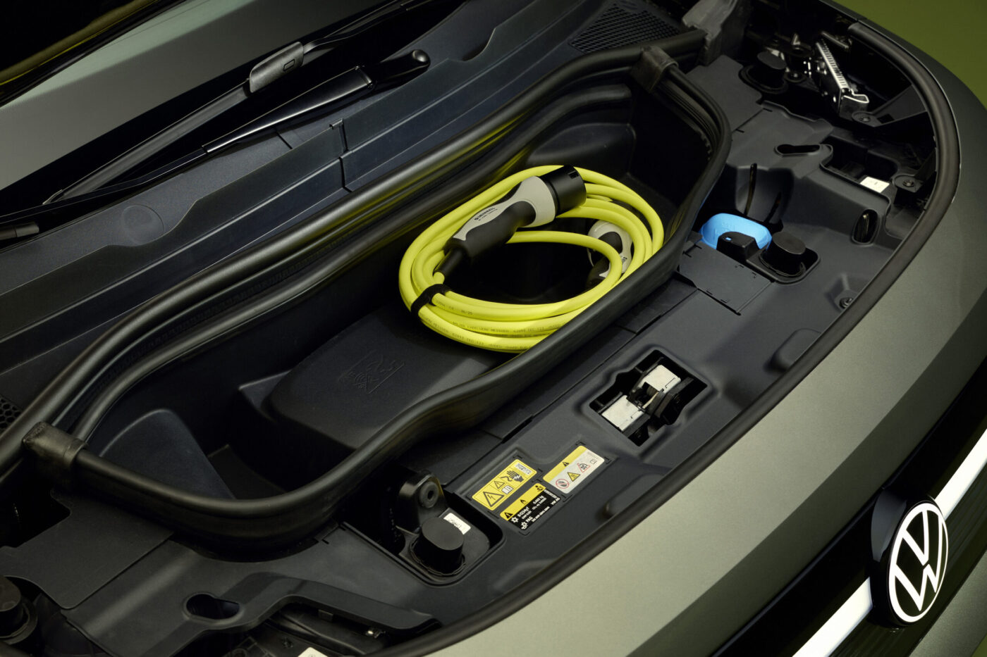 Frunk des VW ID. Cross mit aufgerolltem gelbem Typ-2-Ladekabel, VW-Logo auf der Motorhaube