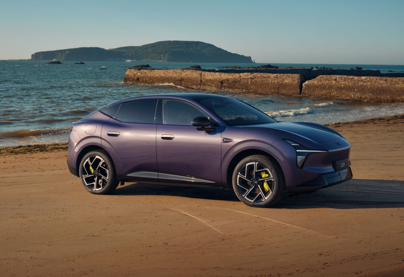 XPENG L03 SUV-Coupé in Violett-Metallic, Seitenansicht an einem Sandstrand