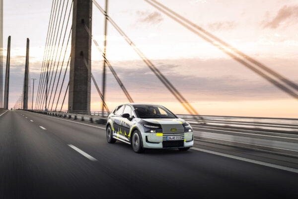 Audi A2 e-tron Prototyp mit Tarnfolie auf einer Hängebrücke bei Sonnenuntergang