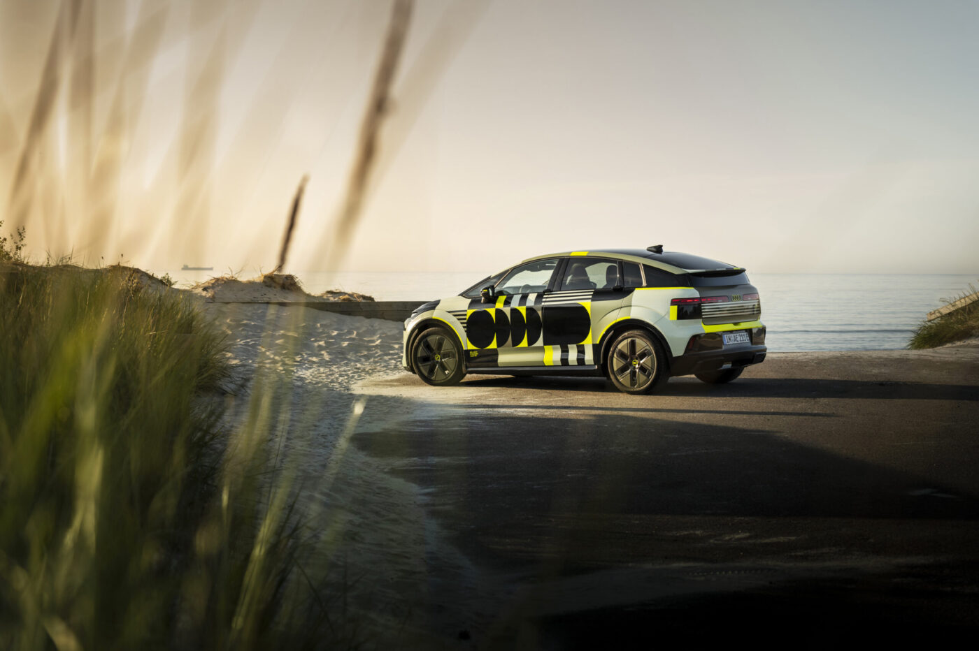 Audi A2 e-tron Prototyp mit schwarz-gelbem Camouflage-Wrap an Küstenstraße