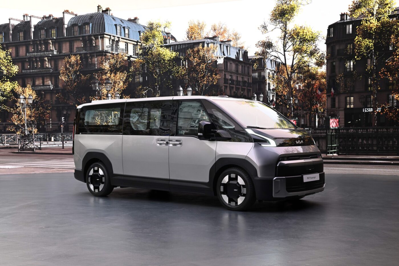 Kia PV7 Passenger in Silbergrau, Schräg-Seitenansicht, vor pariser Stadtkulisse