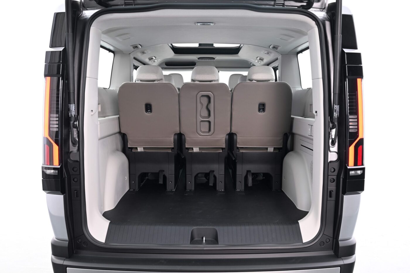 Kia PV7 Passenger: Blick durch geöffnete Heckklappe auf drei Sitzreihen und großen Ladebereich