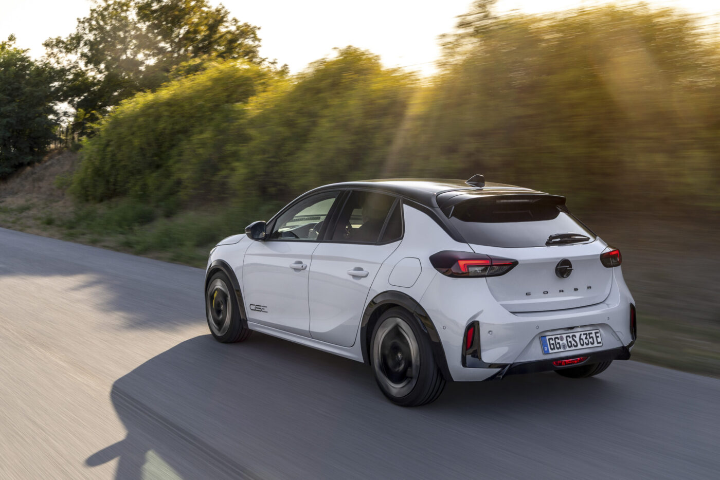 Opel Corsa GSE in Weiß-Schwarz fährt auf Landstraße – Heckansicht schräg links