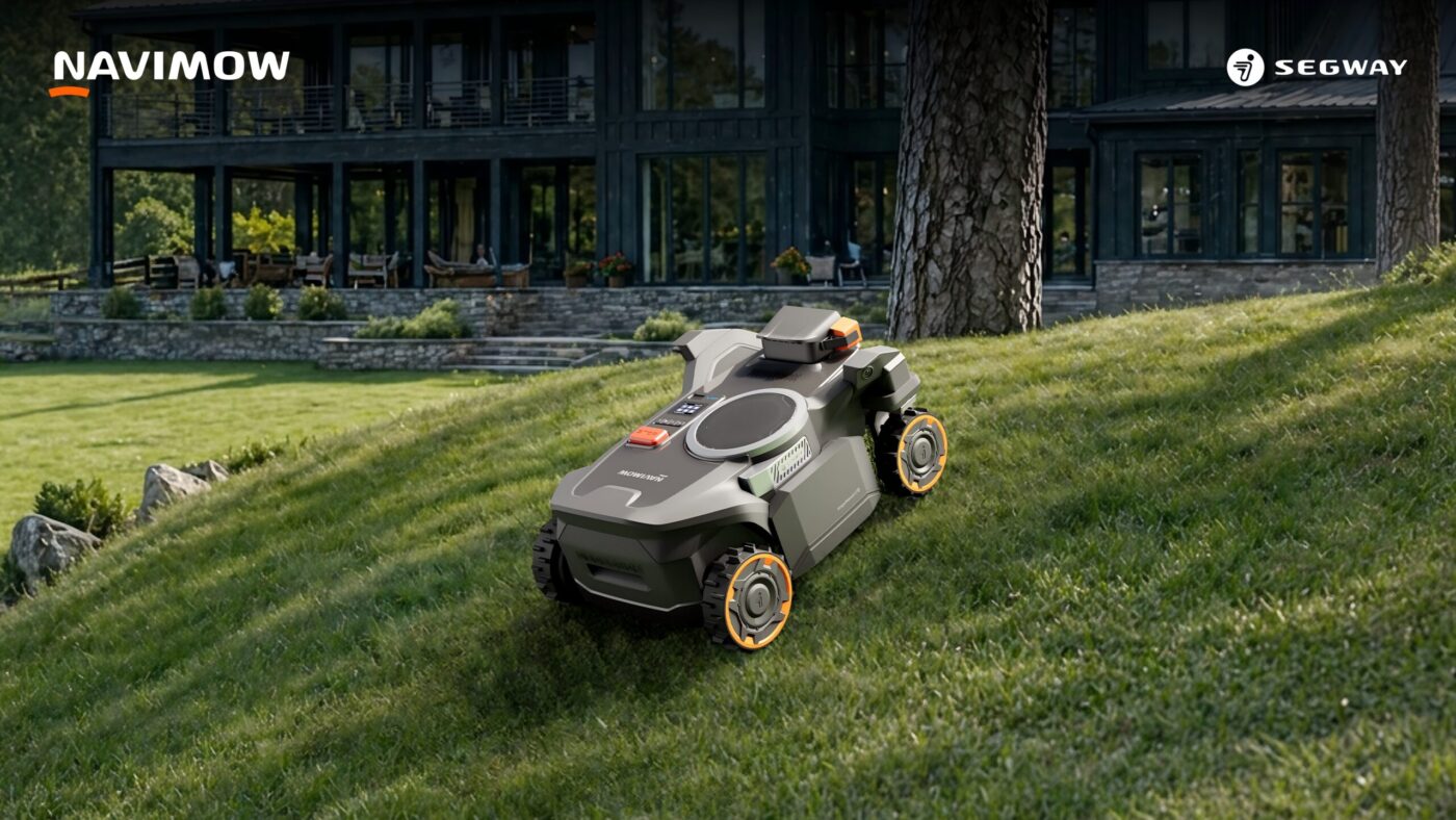Segway Navimow H5 Pro Mähroboter mit Allradantrieb auf abschüssigem Rasen vor Landhaus