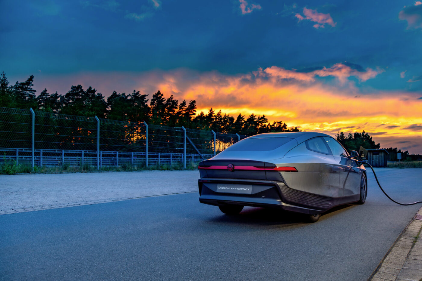 VW Mission Efficiency Coupé von hinten beim Laden, vor dramatischem Sonnenuntergang
