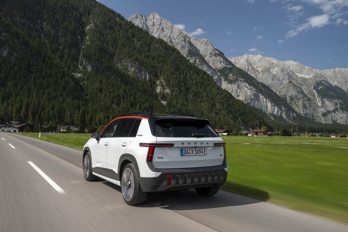 Škoda Epiq in Weiß-Orange von hinten auf einer Alpenstraße fahrend