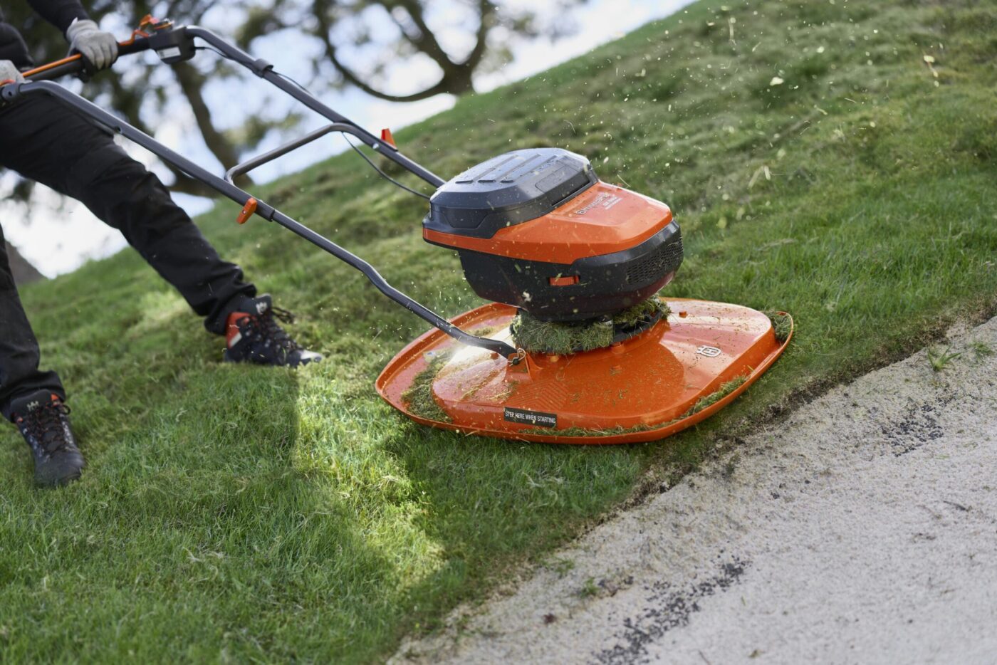 Husqvarna GX 560i Hovermäher im Einsatz an steiler Böschung neben Betonkante