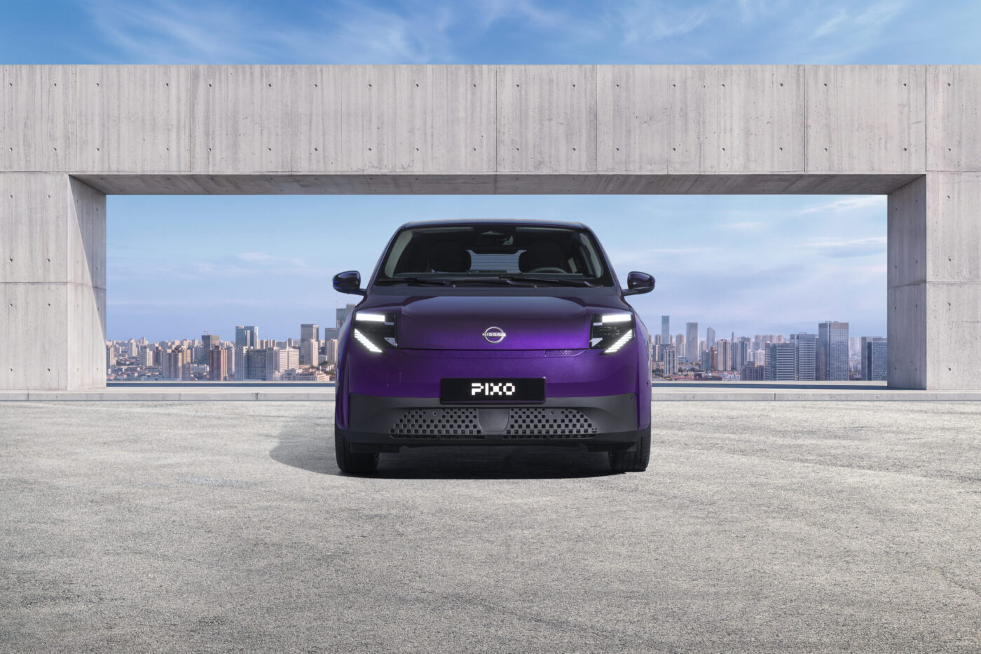 Nissan Pixo Elektro-Stadtwagen in Violett, Frontansicht, vor Stadtkulisse