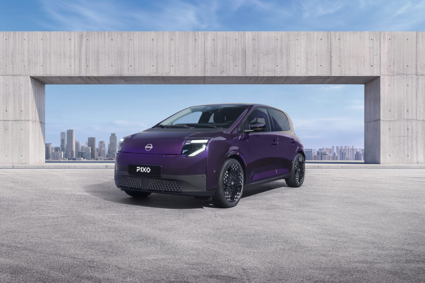 Nissan Pixo Elektro-Stadtwagen in Violett, Frontansicht vor Betonarchitektur mit Skyline