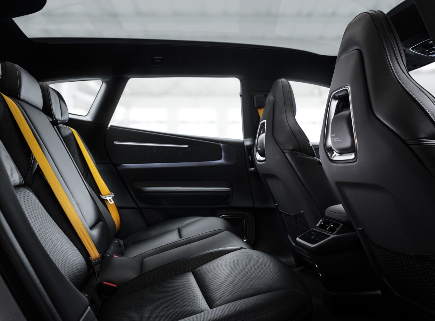 Polestar 4 SUV Fondraum mit schwarzen Ledersitzen und auffälligem gelben Sicherheitsgurt