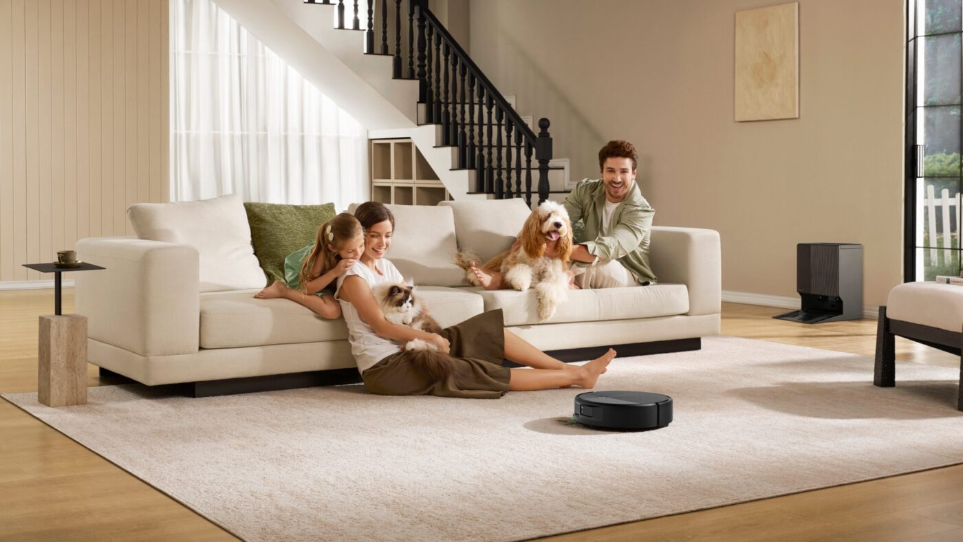 iRobot Roomba Max 875 Combo fährt auf Teppich, während Familie mit Hund und Katze auf Sofa sitzt