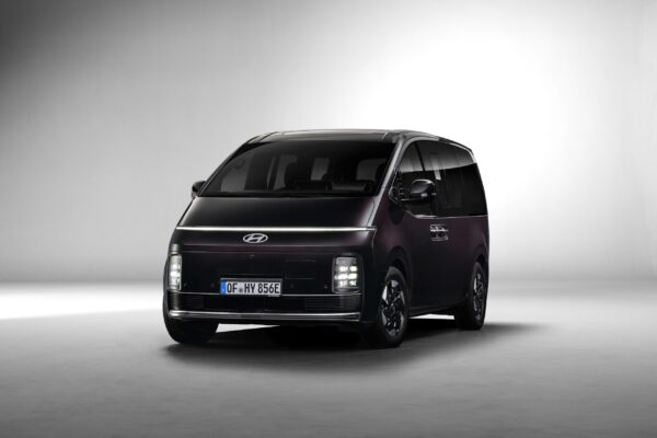 Hyundai STARIA Elektro in Dunkelviolett, Frontansicht im Studio mit blauem E-Kennzeichen