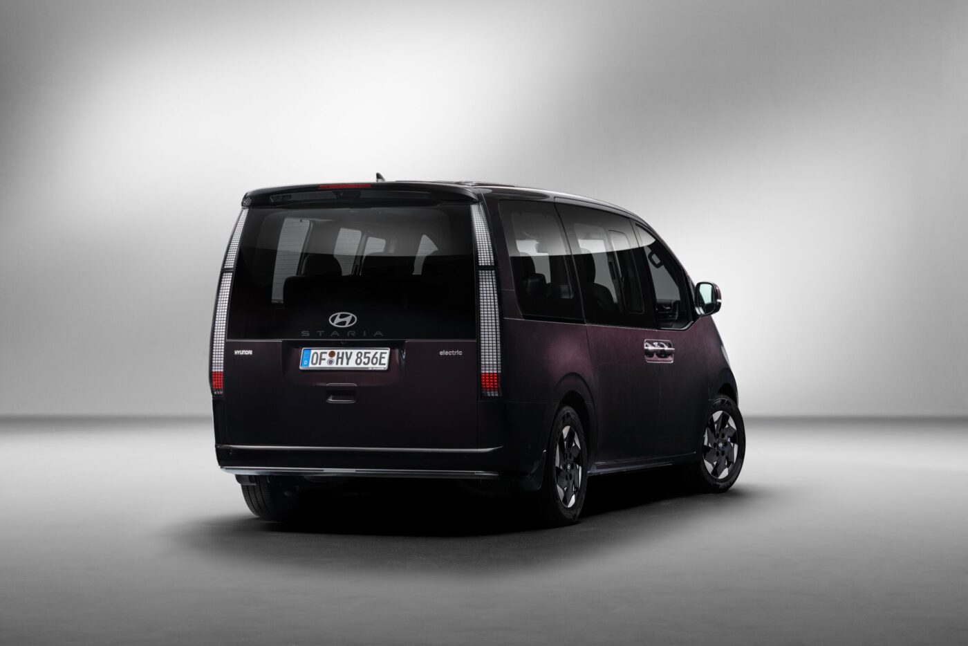Hyundai STARIA Elektro Heckansicht in Dunkelviolett im Studio mit „electric"-Schriftzug