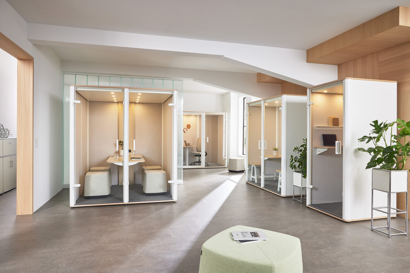 Mehrere bosselino Acoustic Pods von Bosse in einem offenen Büroraum mit Holz- und Glasakzenten